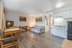 a living room with a couch and a kitchen at Bluebird Motel in Nanaimo