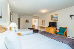 a hotel room with two beds and a television at Bluebird Motel in Nanaimo