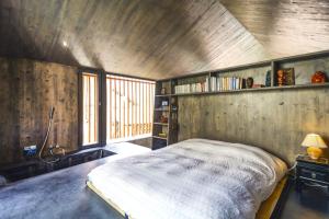 um quarto com uma cama num quarto com paredes de madeira em Renovated historic barn in mountain village em Ollon