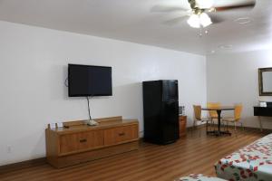 a room with a flat screen tv on a wall at Heritage Inn & Suites in El Dorado