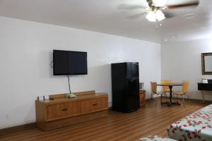 een kamer met een flatscreen-tv aan de muur bij Heritage Inn & Suites in El Dorado