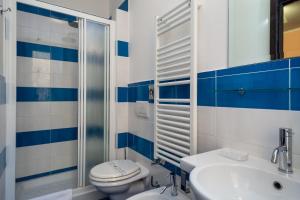 a blue and white bathroom with a toilet and a sink at Mocenigo Vatican Suites in Rome