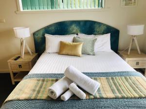 a bedroom with a bed with towels on it at BAY OF FIRES SEACHANGE Ocean frontage in Binalong Bay