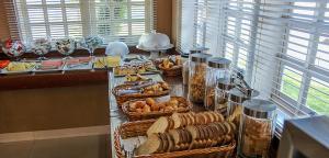 ジャグァリウーナにあるHotel Portal das Águasのカウンターの上にたくさんの食べ物の入ったバスケットが置かれたビュッフェ