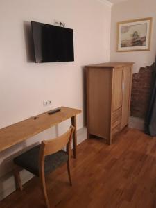 a room with a desk and a television on the wall at LV Rooms & Apartments am Lützowplatz in Berlin