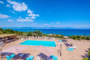 - une vue sur la piscine avec des chaises et des parasols dans l'établissement Hilltop Residences, à Kalamaki