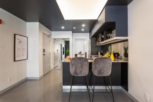una cucina con due sgabelli da bar a bancone di Pierce Boutique Apartments by Simplissimmo a Montréal