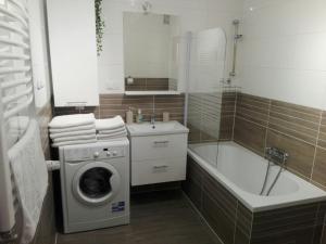 a bathroom with a washing machine and a bath tub at Apartamet Marzenie 7 - Opole in Opole