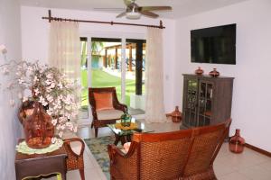 a living room with a table and chairs and a television at EXCLUSIVA VILLA EN LA ZONA HOTELERA DE IXTAPA_ZIHUATANEJO in Ixtapa