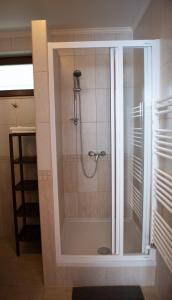 a shower with a glass door in a bathroom at Levendula Apartman in Hegykő