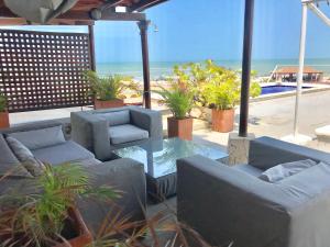 un patio con sofás, una mesa y la playa en Penthouse Caribbean View and private pool, Cartagena, en Cartagena de Indias