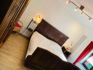 ein Schlafzimmer mit einem Bett mit einem Kopfteil aus Holz in der Unterkunft Ferienhaus Vennblick in Monschau