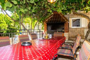 a red table and chairs on a patio at Apartments Jakov in Mirce