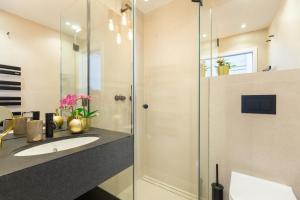 a bathroom with a sink and a glass shower at Old Town House with Floor Heating & Lush Private Garden in Dubrovnik +27 photos