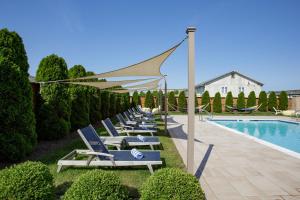 a row of lounge chairs next to a swimming pool at The Ocean Resort Inn in Montauk