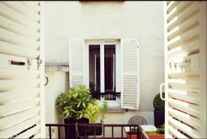 an apartment balcony with a window and plants at Le Victor Hugo in Montrouge