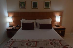 um quarto com uma cama grande e 2 candeeiros em Best Hotel Sobral em Sobral