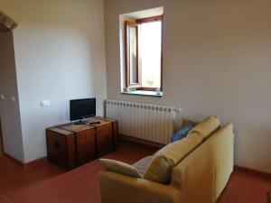 a living room with a couch and a television at Casa Pancole in Cavriglia