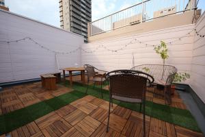 a patio with a table and chairs on a balcony at Casa HANA in Tokyo