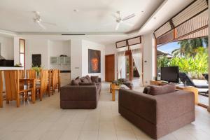 a living room with two couches and a dining room at Mai Tai, luxury 3 bedroom villa in Choeng Mon Beach