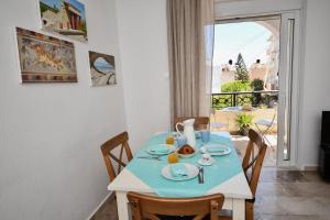 uma sala de jantar com uma mesa e cadeiras e uma janela em Central flat, 300m from the beach em Lerápetra