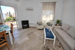 uma sala de estar com um sofá e uma mesa em Central flat, 300m from the beach em Lerápetra