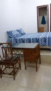 a bedroom with a bed and a chair and a table at Bahia Flat in Salvador