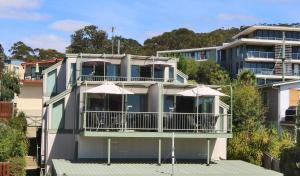 a house with a balcony and a large window at Anchorage Motel & Villas Lorne in Lorne