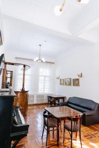 a living room with a couch and tables and a piano at Lion B&B in Samarkand