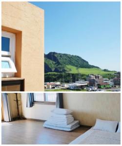 西歸浦的住宿－城山早晨日落度假屋，客房设有一张床和享有山景的窗户