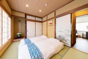 a bedroom with a large bed in a room with windows at Shirakabanoyado - Uehonmachi in Osaka