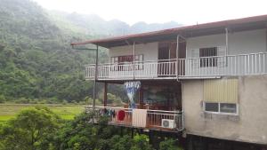 a building with a balcony with an umbrella on it at Ba Be Lake Homestay - Quynh Chi in Ba Be18