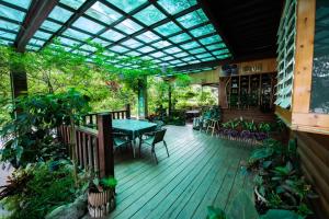 an outdoor deck with a table and chairs and plants at Rui Li Yinxiang Qu Homestay in Meishan