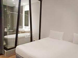 a bedroom with a bed and a tub and a sink at Vismaya Suvarnabhumi Hotel in Lat Krabang