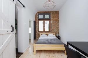 a bedroom with a bed and a brick wall at Sopotel in Sopot