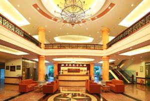 un vestíbulo de un hotel con sillas naranjas y una lámpara de araña en DLGL - Dung Quat Hotel, en Binh Thanh