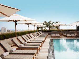 a row of lounge chairs and umbrellas next to a swimming pool at Santa Monica Proper Hotel, a Member of Design Hotels in Los Angeles