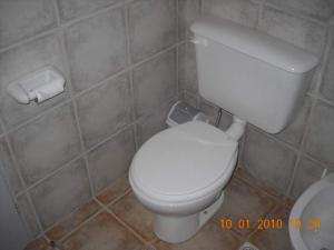 Un baño con un inodoro blanco en una habitación. en Cabaña Tío Miguel, en Los Molles 13 fotos más