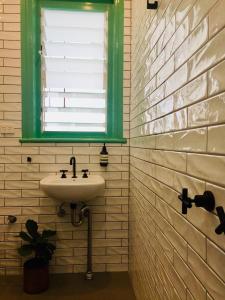een badkamer met een wastafel en een raam bij Coogee Beach House in Sydney