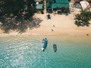 an aerial view of a boat in the water next to a beach at Tioman Cabana Bed & Breakfast in Tioman Island