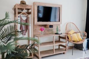 a living room with a tv on a wooden shelf at Pesona Beach Resort & Spa in Gili Trawangan