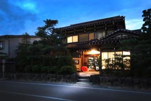 una casa japonesa por la noche con las luces encendidas en Ichinomatsu Japanese Modern Hotel en Takayama