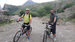 two men standing with their bikes on a dirt road at Hotel Grabova in Grabova e Sipërme