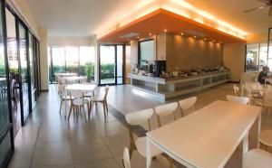 restauracja ze stołami i krzesłami oraz kuchnią w obiekcie ABIZZ Hotel Lampang Airport w mieście Lampang