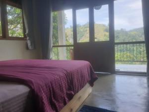 a bedroom with a bed and a large window at Raveena Guest House in Ella