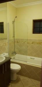 a bathroom with a toilet and a tub and a sink at Ocean View Villas A08 in Port Edward
