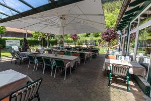 ムーラウにあるEgidiwirt Murauのテーブルと椅子、傘が備わるレストラン