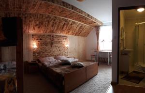 a bedroom with a bed and a brick wall at Zielony Domek in Tylicz