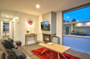 a living room with a couch and a fireplace at Highview Central in Queenstown