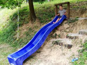 Holiday Home Vesenjak في ماريبور: صبي صغير يجلس على زحليقة زرقاء